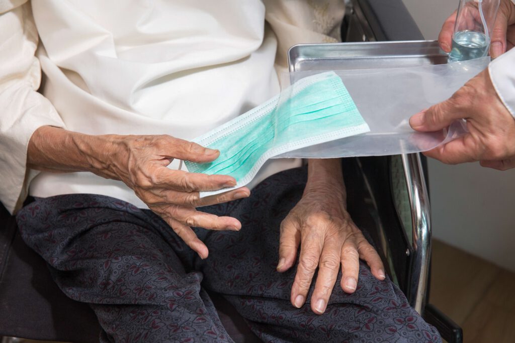 Entrega de mascarillas a une mujer mayor en el servicio de atención domiciliaria de La Laguna. 